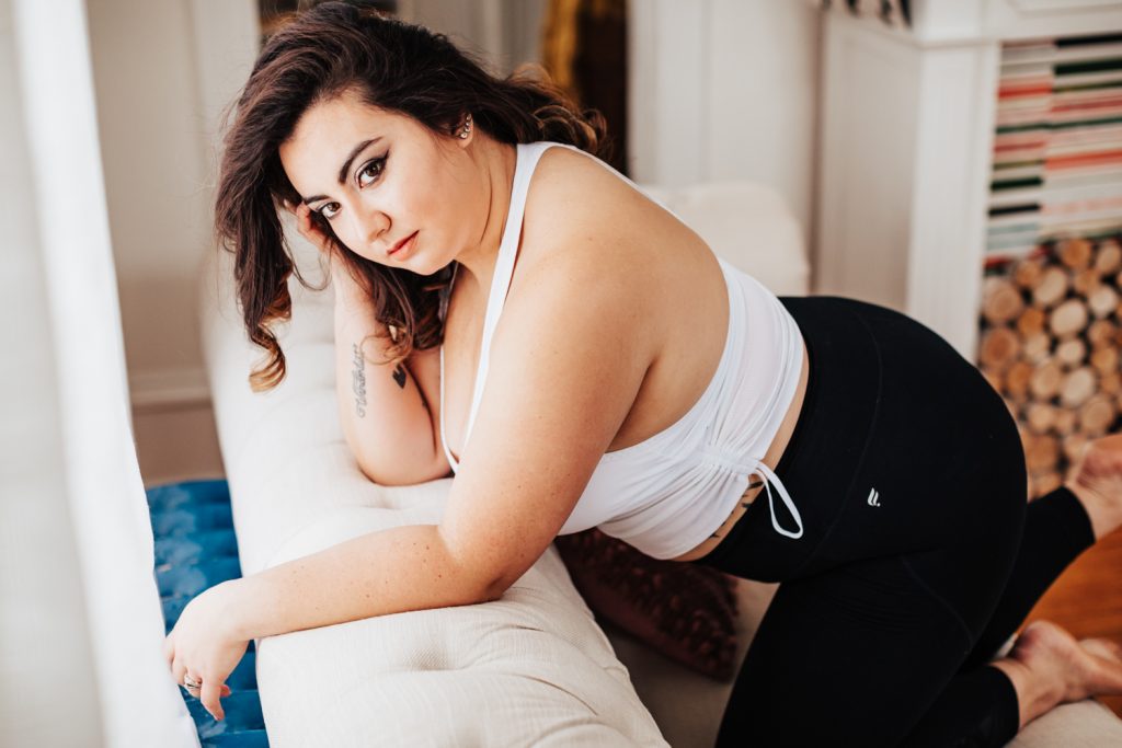 muse casandra on the leaning on the back of couch wearing fabletics work out wear.